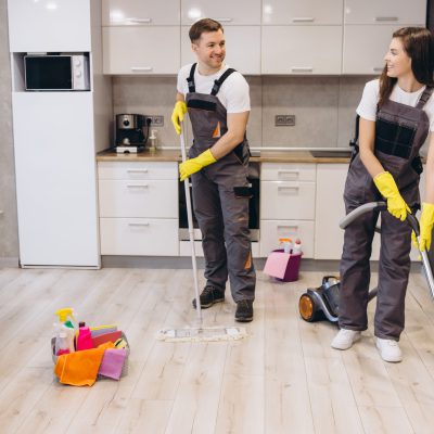 Professional cleaners washing floors and vacuuming in a modern apartment, ensuring a spotless and hygienic living space with teamwork